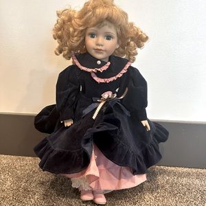 Porcelain doll with navy and pink coat